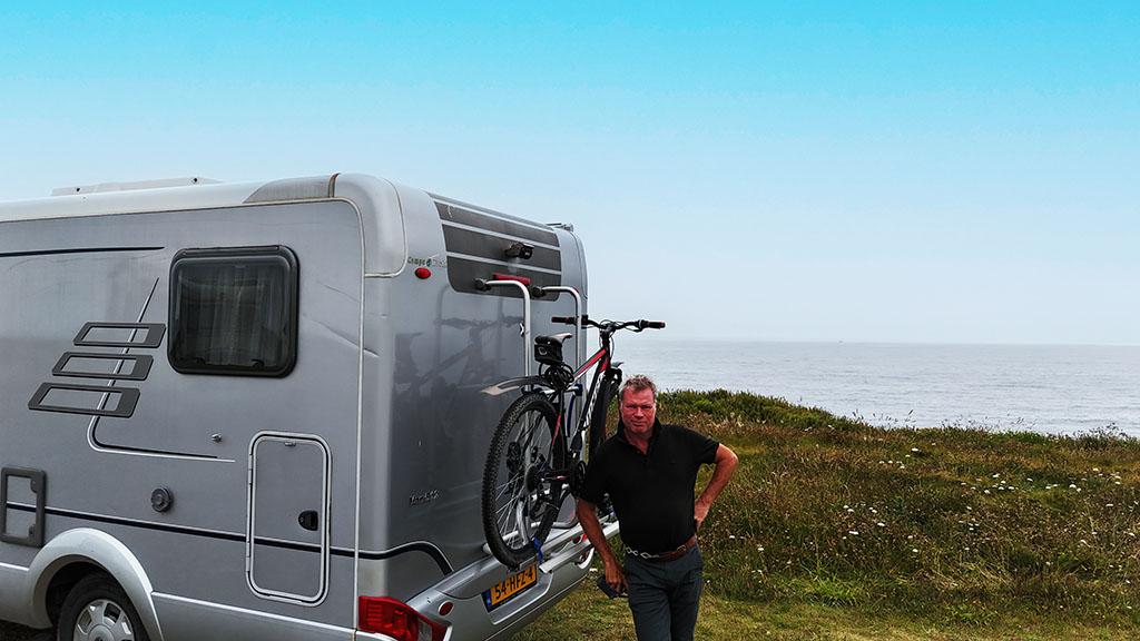 Herman Slagter leaning against camper